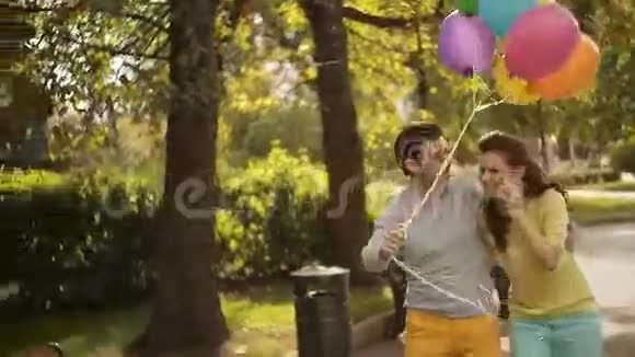 恋爱中的男人和女人恋人们手持气球飞翔视频的预览图