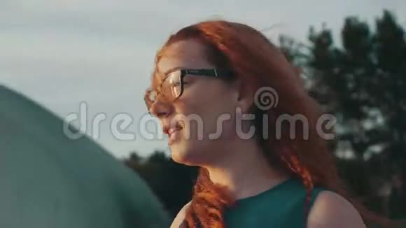在摩托艇上戴眼镜的红头发女孩美丽的夏日夜晚娱乐视频的预览图