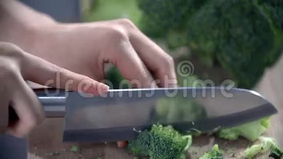 在全新的厨房里用一把大菜刀切花椰菜的近镜头视频的预览图