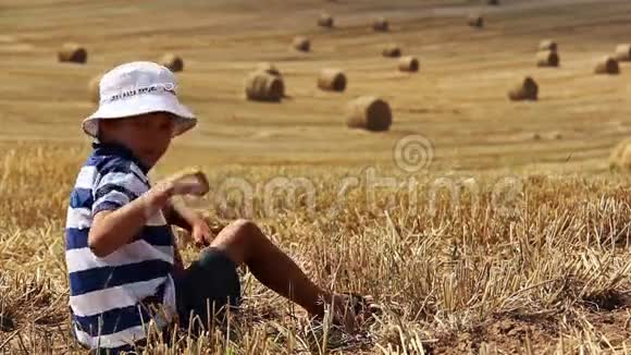 男孩坐在农场的田野里做手势课很多干草堆视频的预览图