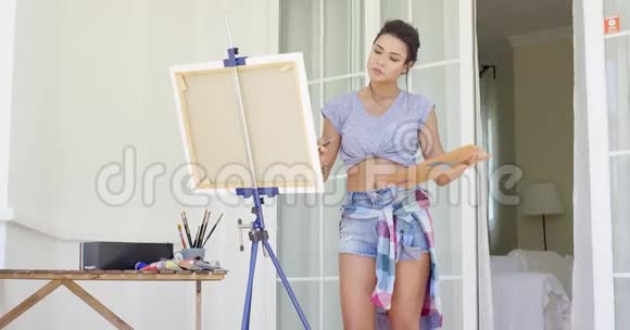 漂亮的女画家在她的露台上作画视频的预览图