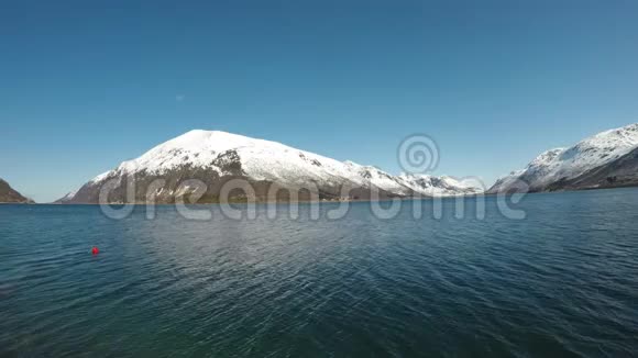 雄伟壮丽的雪山下面有平静的蓝色深峡湾视频的预览图