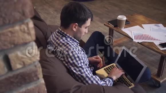 一个男人坐在椅子包里在网上买东西视频的预览图