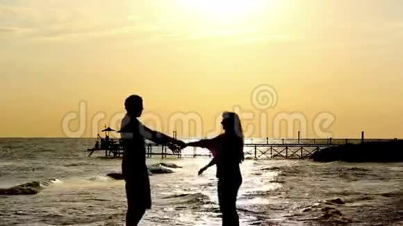 日落时海边的剪影情侣视频的预览图
