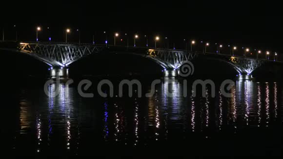 俄罗斯萨拉托夫和恩格斯城市之间的路桥伏尔加河晚上的车灯和路灯视频的预览图