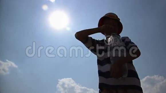 酷热男孩喝水在阳光下倒水口渴中暑视频的预览图