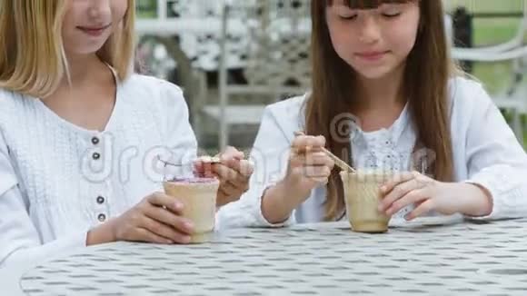 两个微笑的女孩或快乐的孩子在户外吃冰淇淋视频的预览图
