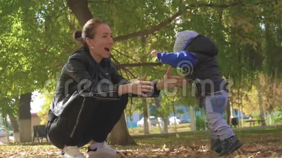 妈妈在一个秋天的公园里围着一个小儿子转秋天公园的幸福家庭慢生活中的幸福家庭视频的预览图