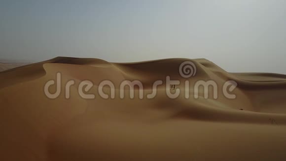 两个女人在日出时走在沙丘上从无人机上看视频的预览图