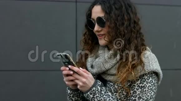 戴太阳镜的年轻女人很高兴收到他男朋友的留言视频的预览图