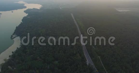 乡间小路穿过河边的树林视频的预览图