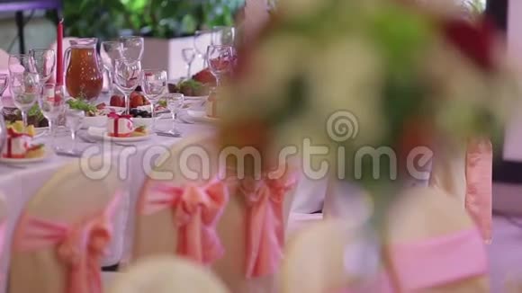 婚礼大厅装饰着鲜花和丝带全是食物的桌子视频的预览图