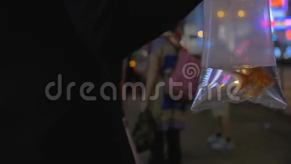 女人手臂的慢动作视图持有塑料包装与金鱼和去购物中心中国香港视频的预览图