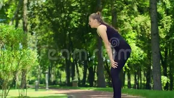 疲惫的女运动员在户外奔跑后健身妇女放松视频的预览图