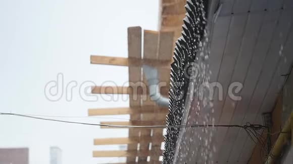 雨滴从亭子的屋顶落下雨滴流下来特写视频的预览图