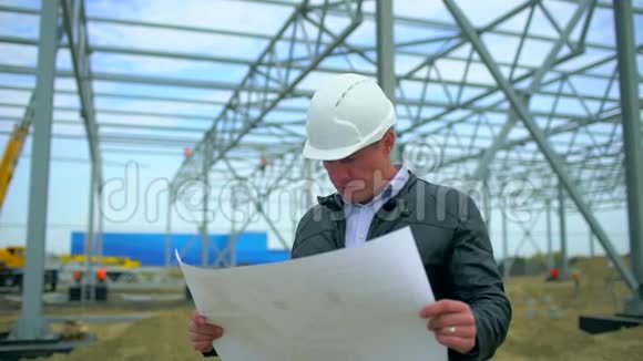 男工程师建筑师建筑主管戴安全帽绘制蓝图他检查质量视频的预览图