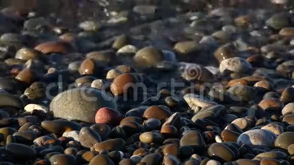 平静的海浪大海清澈的海水抚摸着石头和鹅卵石近距离的水声视频的预览图