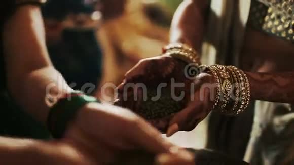 女人把绿色的谷物放在新娘的手掌上视频的预览图
