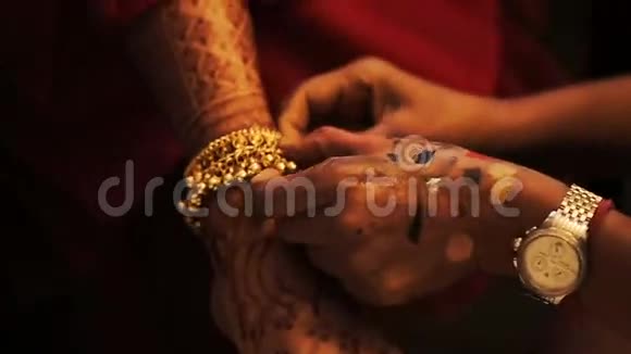 女人把华丽的手镯放在新娘的手上视频的预览图