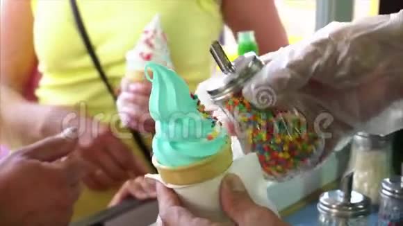 街头小贩用甜的彩色球洒冰淇淋华夫饼筒视频的预览图