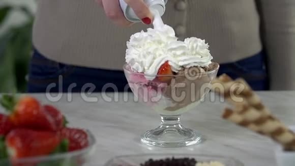 把甜奶油放在一杯冰淇淋上视频的预览图