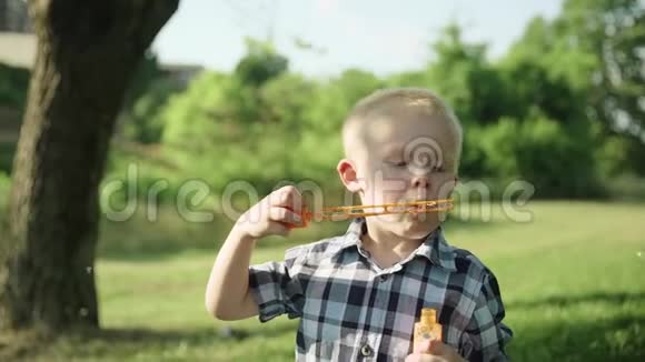 小男孩吹肥皂泡夏季公园慢动作全高清视频的预览图