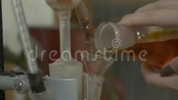 绿色液体的化学玻璃倒入漏斗中的红色玻璃手在烧瓶中加入红色混合液体化学家视频的预览图