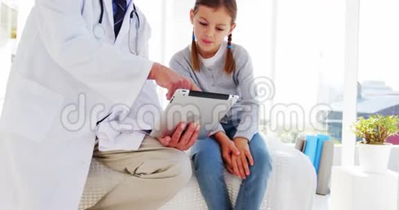 男医生和女孩讨论数字平板电脑视频的预览图
