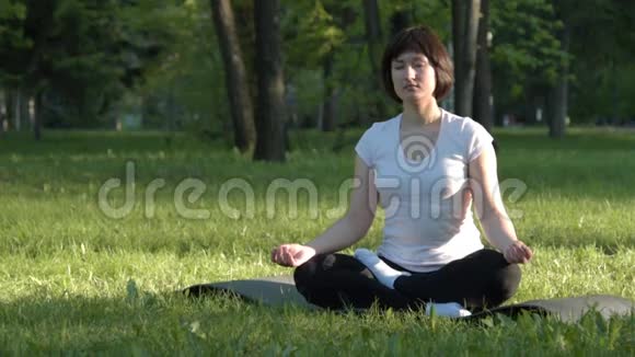 日落时分在公园里做瑜伽的女孩视频的预览图