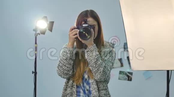年轻的女摄影师配备专业摄影棚视频的预览图