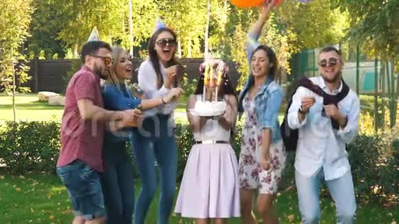 一群朋友戴着派对帽和派对喇叭玩得开心庆祝生日视频的预览图