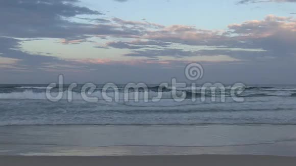 黄昏时的天空在澳大利亚昆士兰东南部的黄金海岸的湿沙上反射视频的预览图