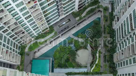 公寓街区外装饰花园中人们的空中时光视频的预览图