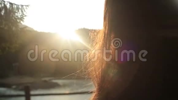 一个美丽的黑发少女头发上有阳光年轻的森林仙女站在码头上享受视频的预览图