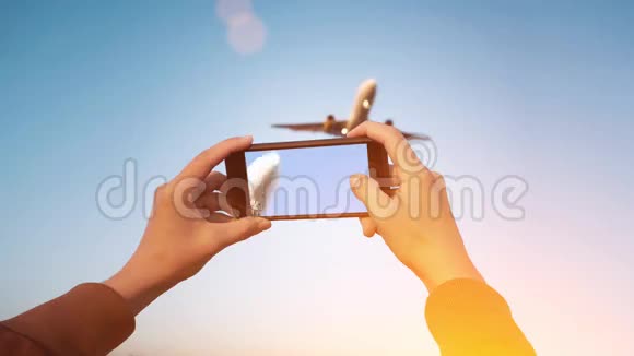 手握智能手机的折叠式电影机同时录制飞机着陆视频视频的预览图