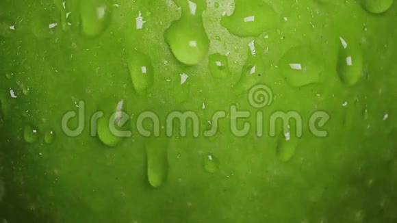水滴沿着绿色苹果的表面向下流动视频的预览图