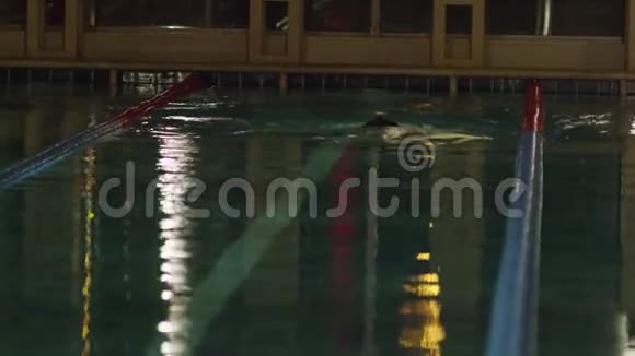 运动员在游泳池里游泳英俊的男人在游泳池里游泳年轻人在游泳池里训练视频的预览图