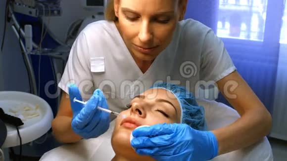 医生在女性病人嘴唇上插入面部注射视频的预览图