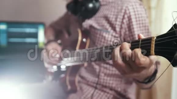 男音乐家用电脑编录吉他的配乐重点放在手和乐器上视频的预览图