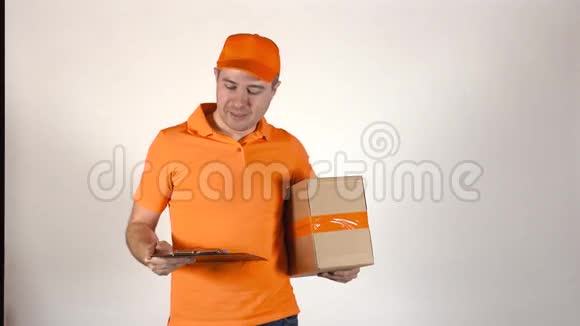 穿橙色制服的快递员送包裹浅灰色背景4K摄影棚拍摄视频的预览图