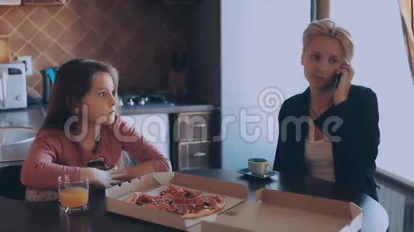 妈妈和女儿在厨房吃披萨视频的预览图