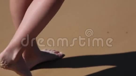 女孩赤脚走在潮湿的沙滩上的腿视频的预览图