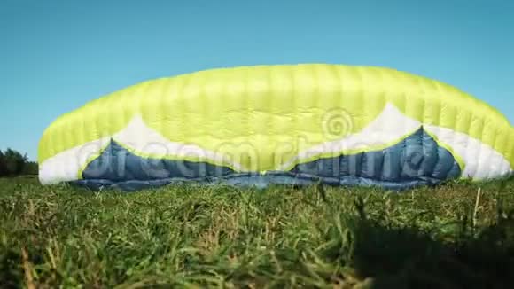 滑翔伞女孩滑翔伞准备在一座绿色的小山上起飞视频的预览图