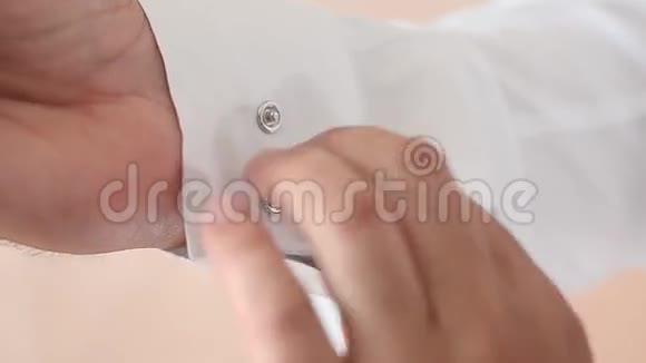 男人把扣子系在白色衬衫的袖子上男人穿上白色衬衫视频的预览图