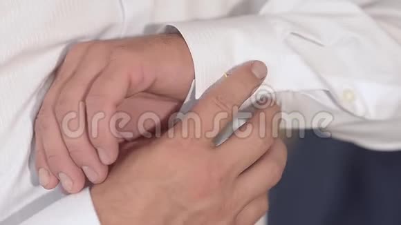 男人把扣子系在白色衬衫的袖子上男人穿上白色衬衫视频的预览图