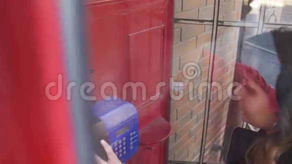 红电话亭里的快乐女孩在街上打电话视频的预览图