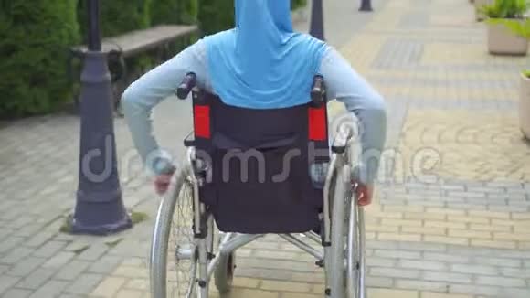 戴着轮椅的传统围巾残疾的阿拉伯青年妇女视频的预览图