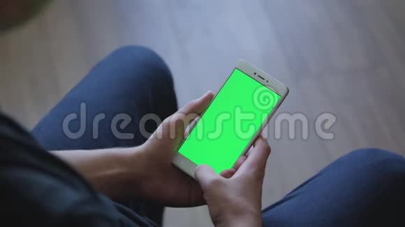 特写男性手拿智能手机与绿色屏幕预键效果有效的移动应用程序预订视频的预览图