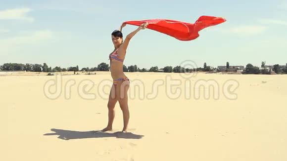 站在海滩上的红色莎朗风女视频的预览图