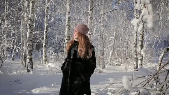 一个漂亮的女人很快乐在冬天在公园里散步视频的预览图